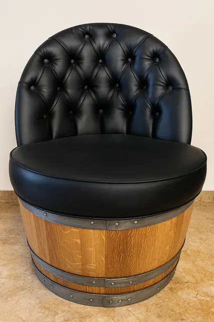 An armchair built into a halved barrel, upholstered in dark leather.