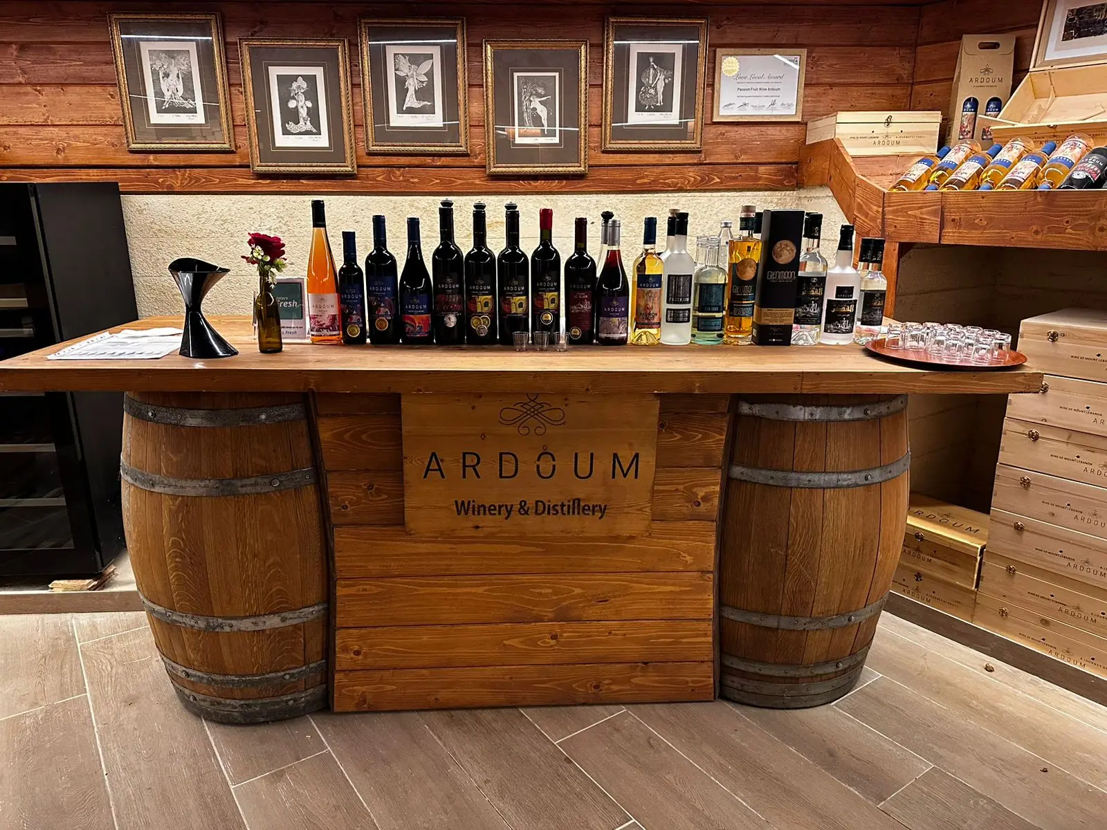 A tasting-room counter built from three barrels, lined with bottles, inside a Bekaa winery.